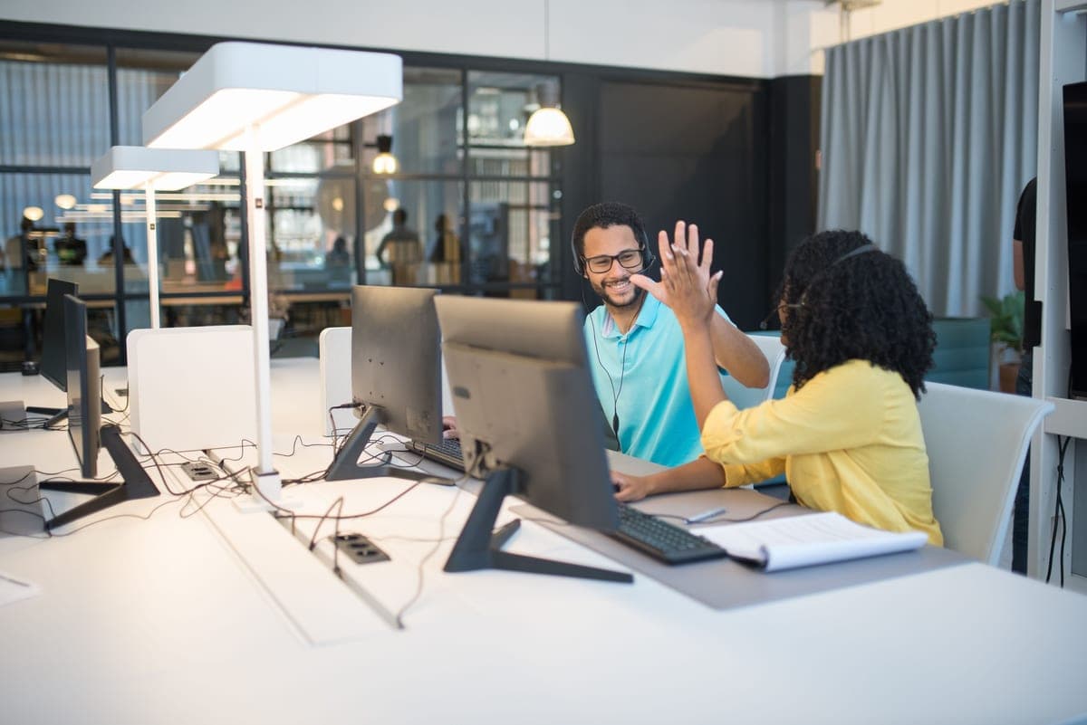Five colleagues working at desks in a compact open-plan office
