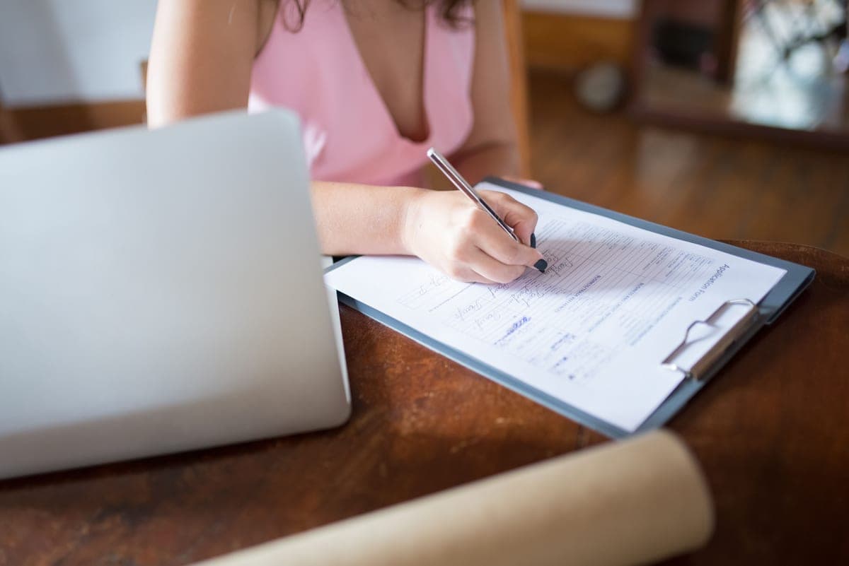 Person completing an online form on a laptop at a small business desk
