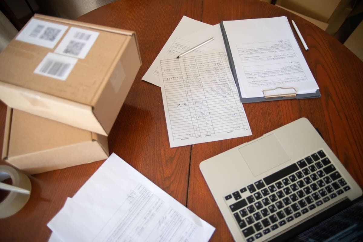 Home office desk with a laptop and a delivery box, contrasted with business supplies