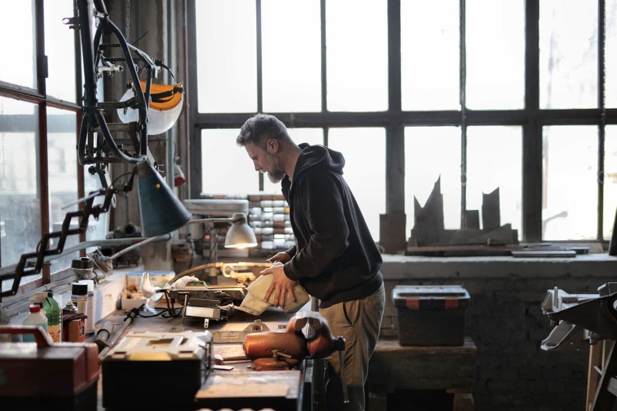 Small business owner reviewing paperwork at a workbench in a workshop